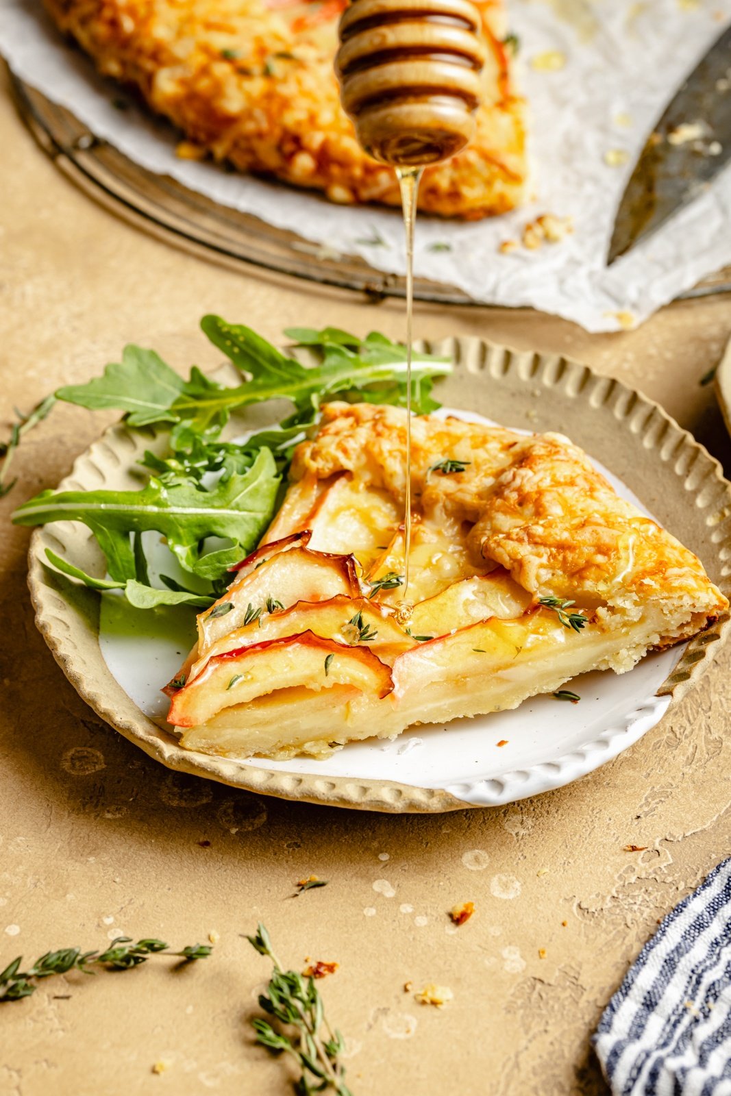 drizzling honey on a slice of apple cheese galette