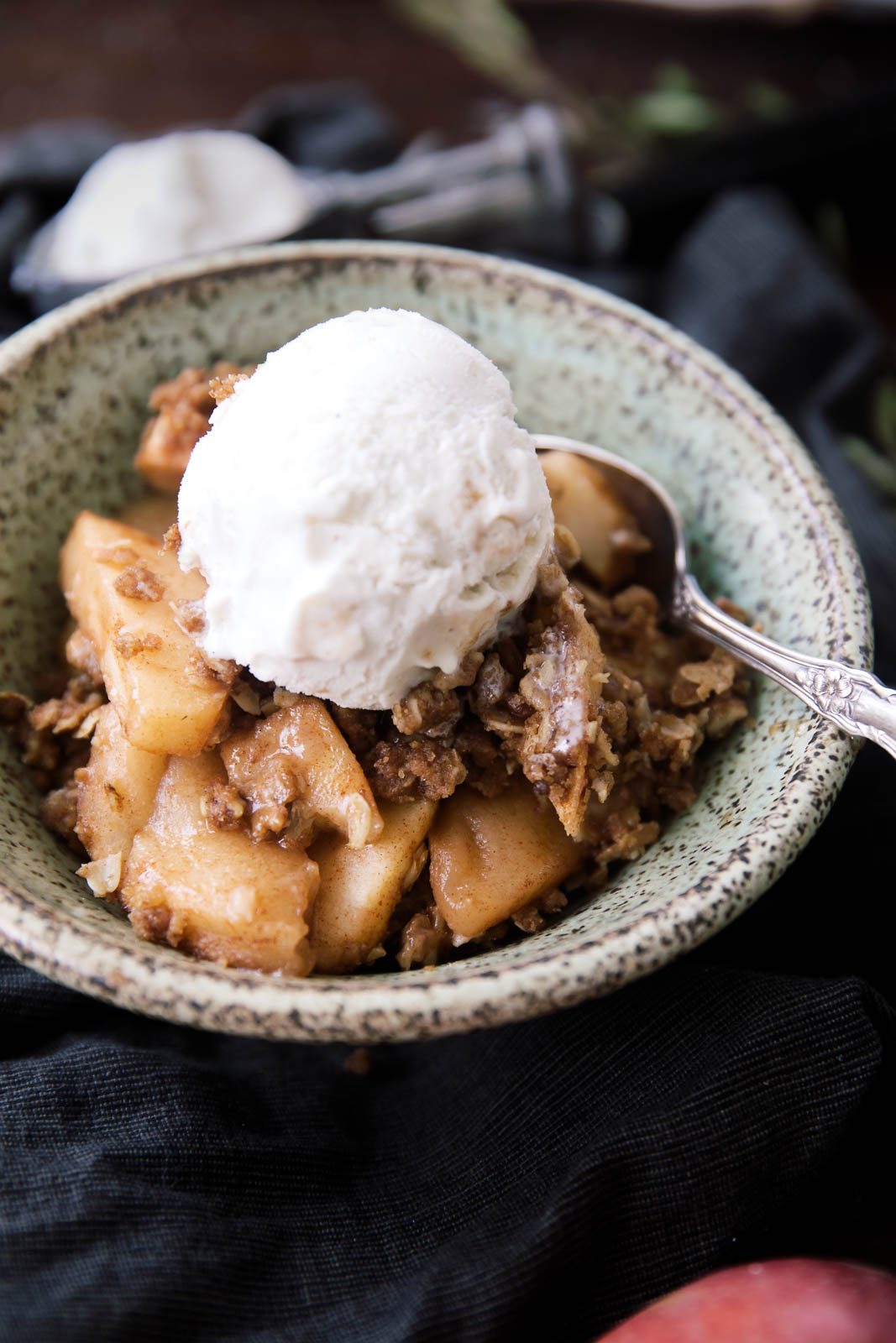 Healthy Apple Crisp in a bowl with ice cream and a spoon