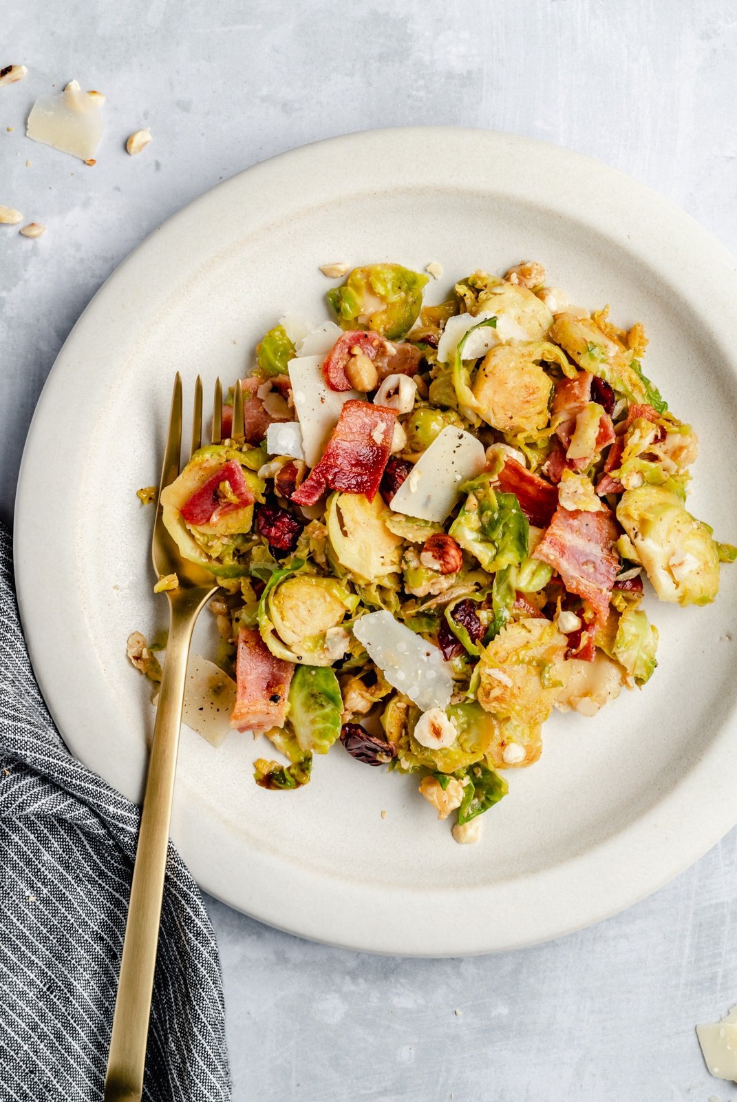 warm brussels sprouts salad with bacon on a plate with a fork